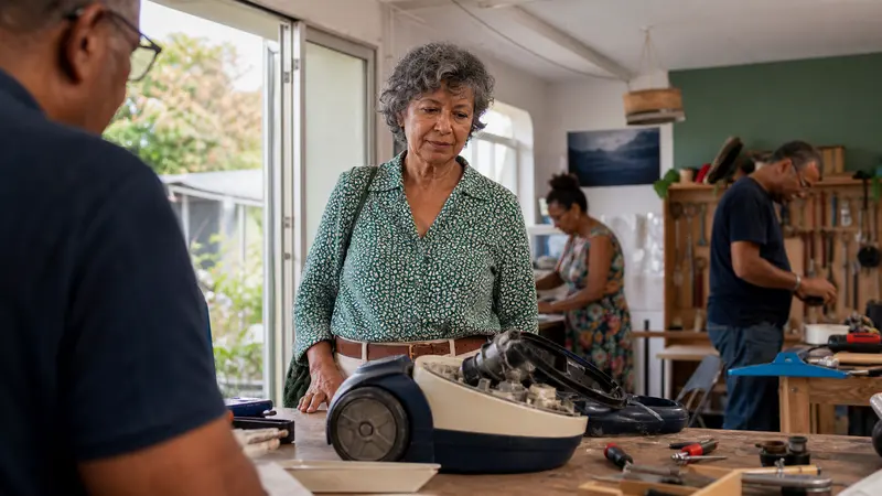 Professionnelle de plus de 55 ans évaluant une mission concrète dans un atelier de réparation associatif